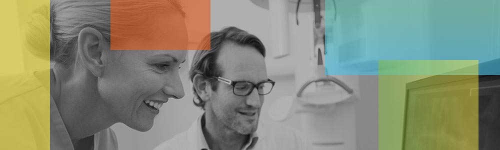 Smiling Dentist Looking at Computer