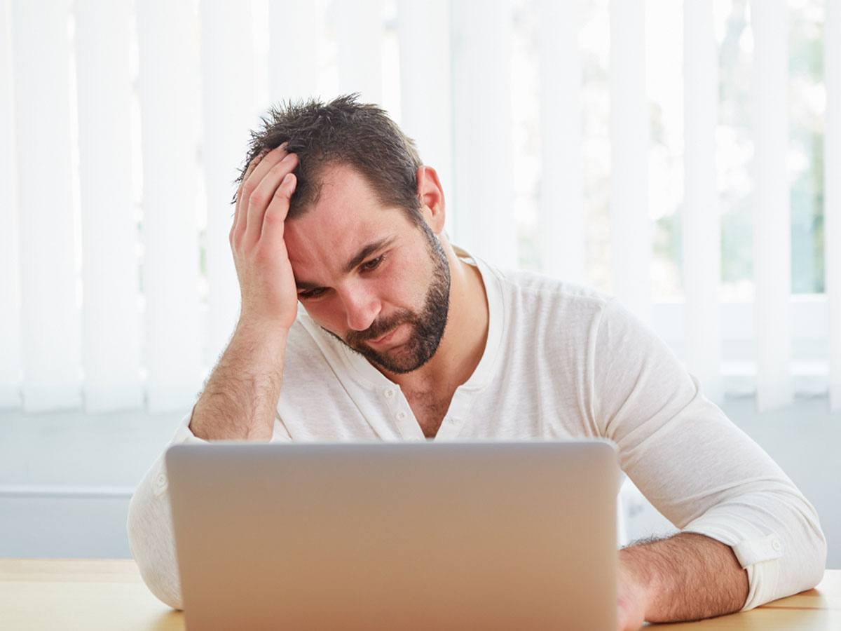 someone looking at their computer frustrated 