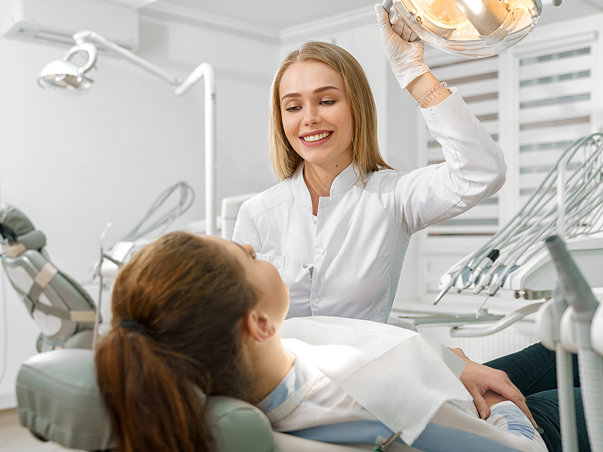 Smiling dentist beginning to work on a patient
