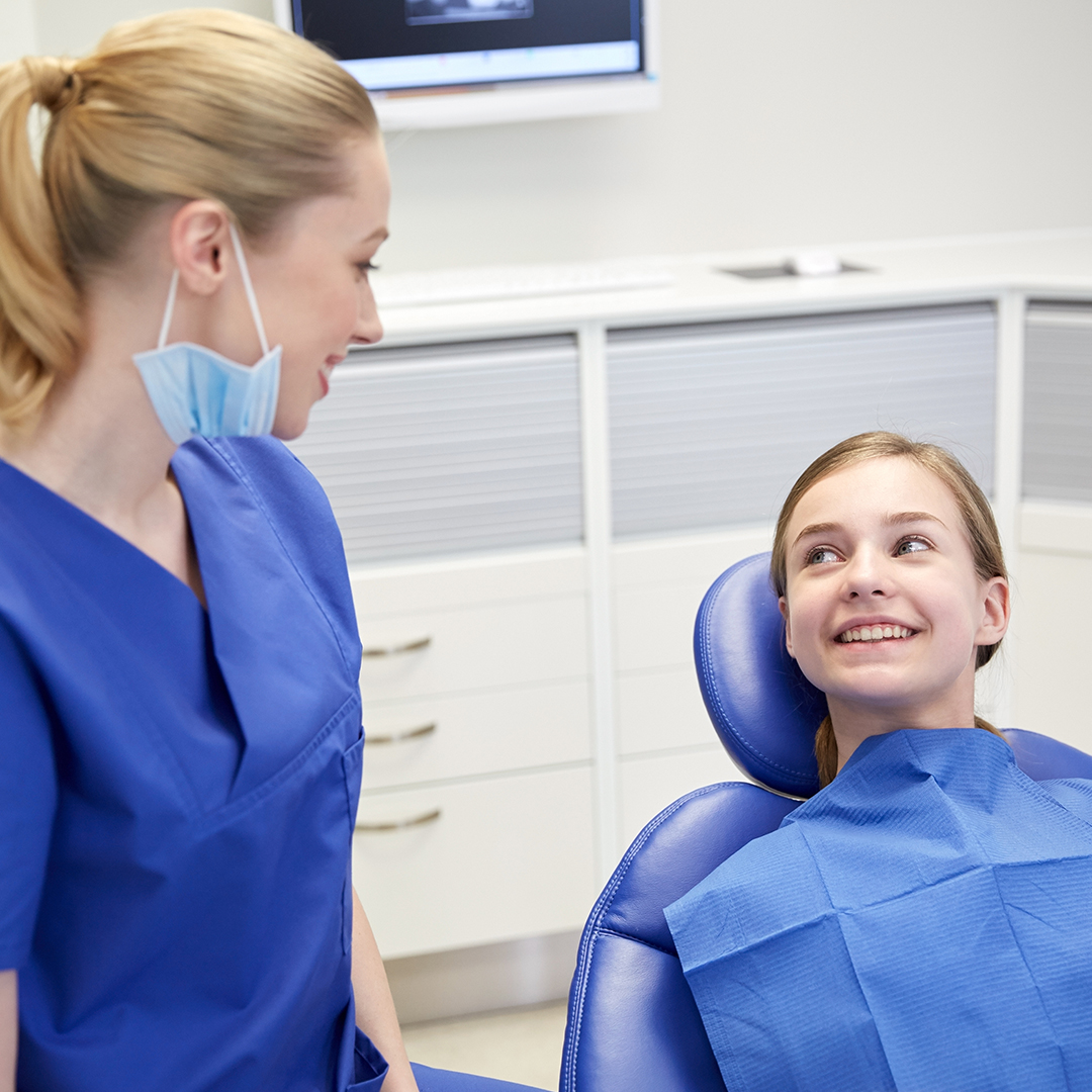 Image of a woman smiling in a dentist chair