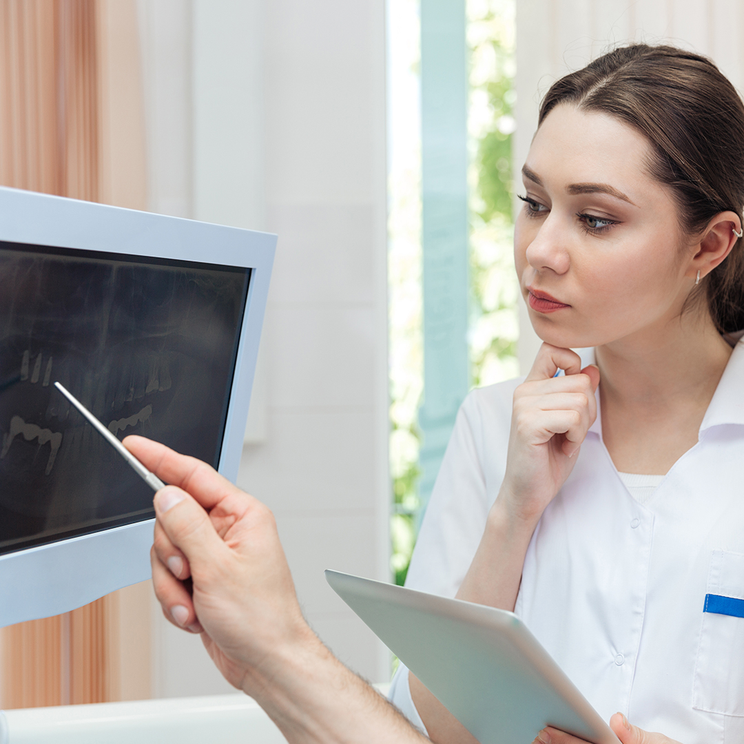 Image of a dentist looking at xrays on a monitor