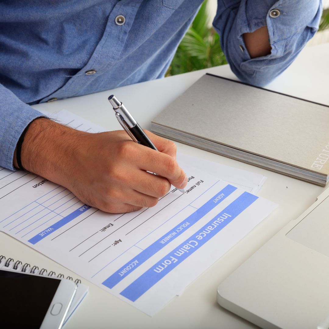 person filling out claim forms