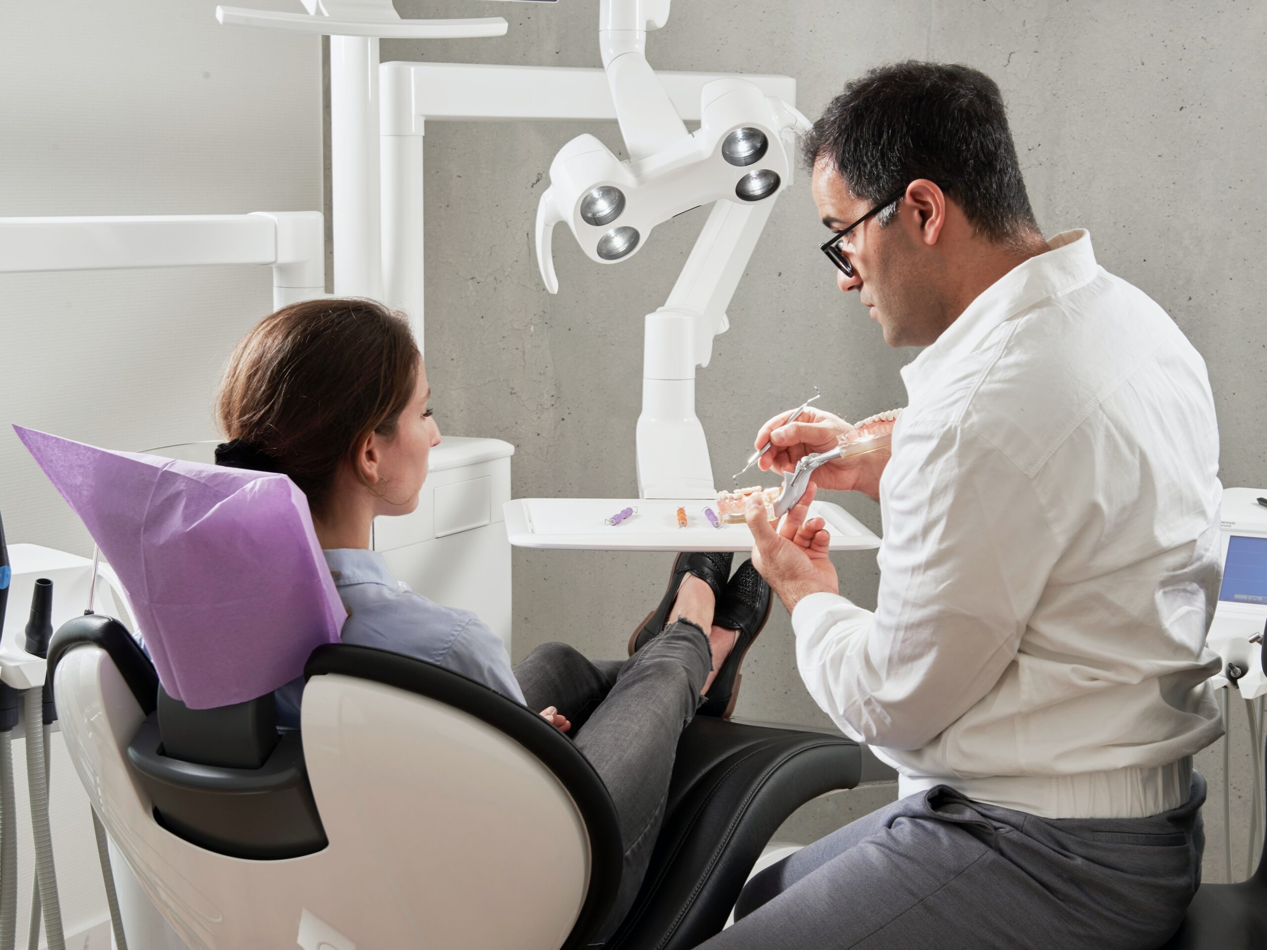 Professional dentist engaging in a consultation with a patient in a modern office setting, discussing oral health and treatment options.