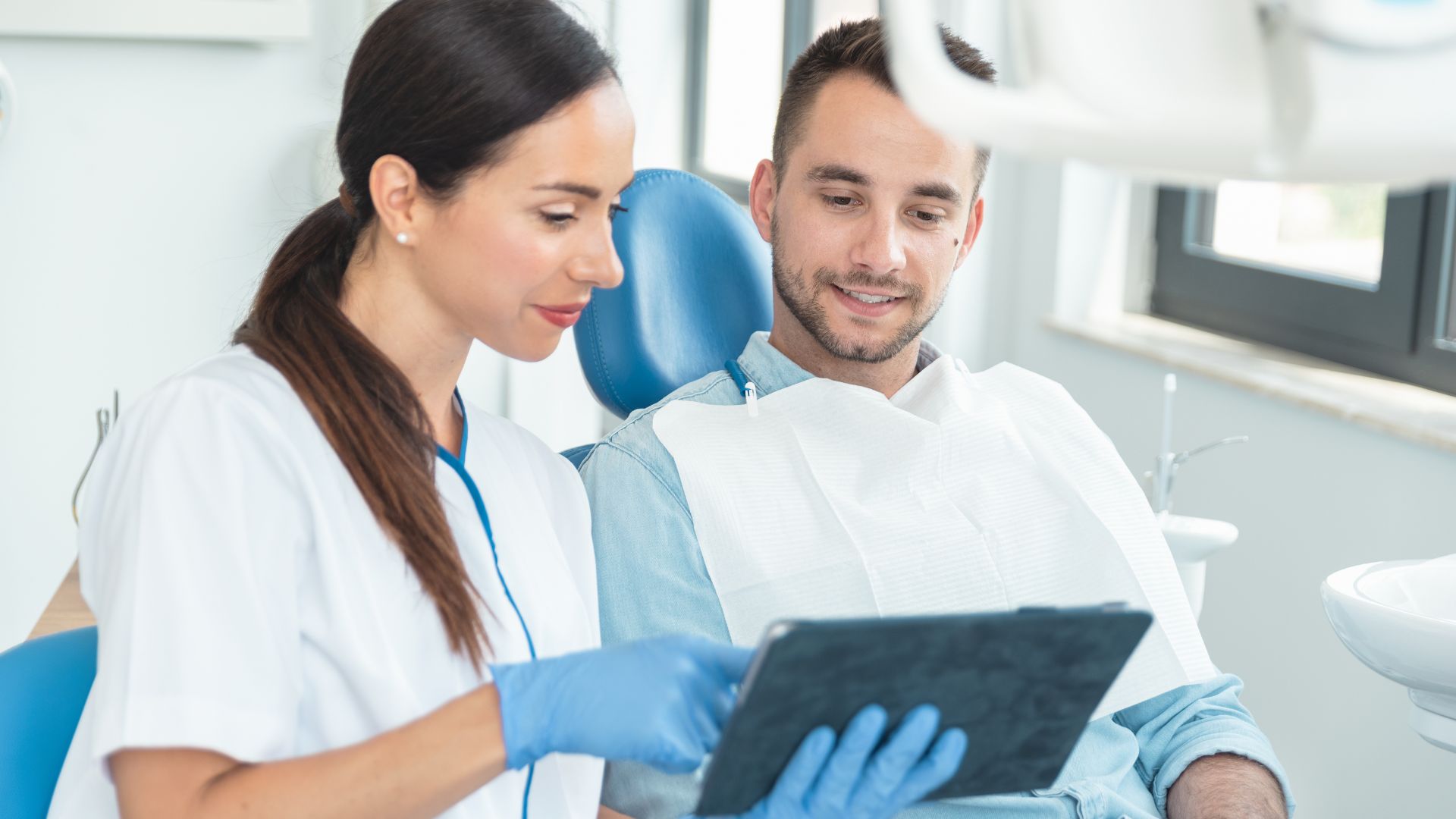dentist sharing information on a tablet with patient
